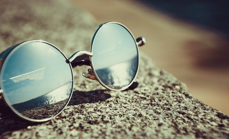 silver framed hippie sunglasses on concrete