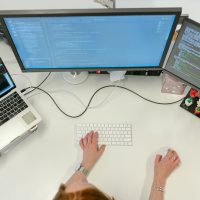 female software engineer coding on computer